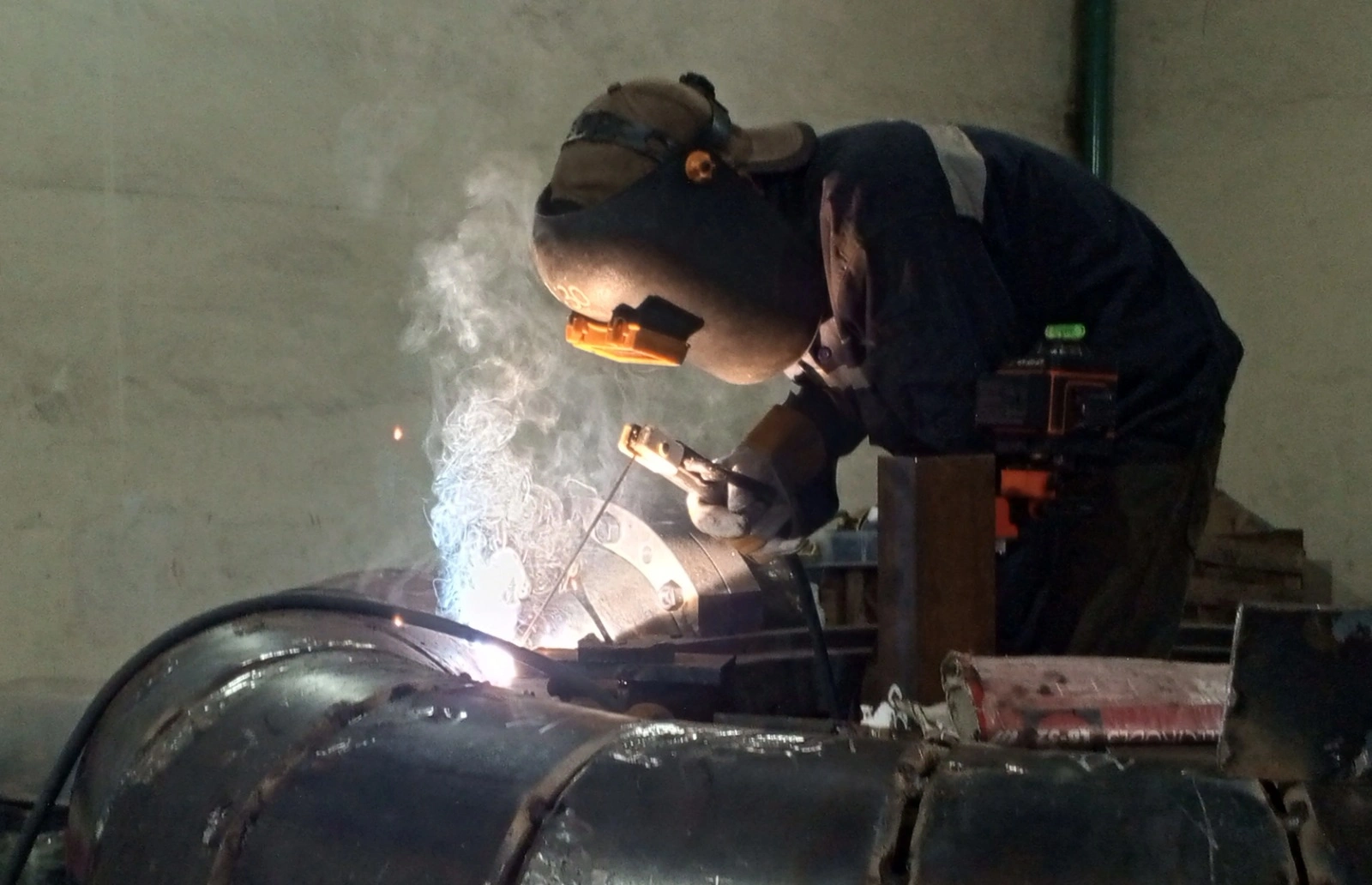 Industrial welder performing precision welding on metal pipe